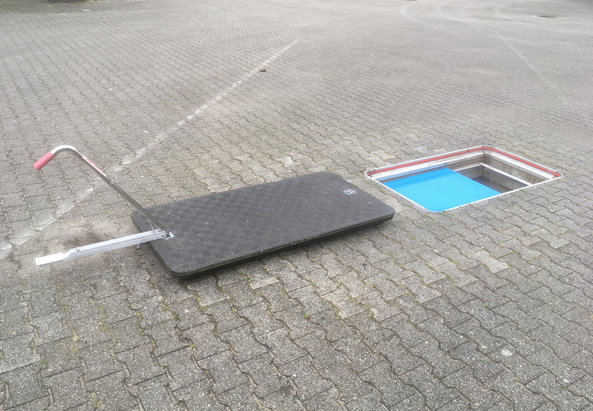 Eine GFK-Schachtabdeckung wird mit einem Spezial-Aushebewerkzeug einfach und bequem ausgehoben