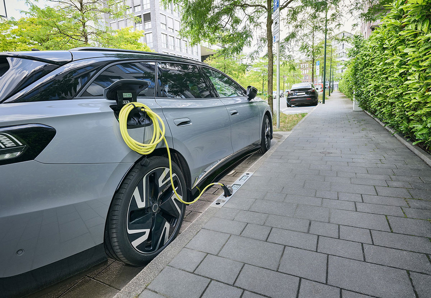 Ein E-Auto wird an einem Ladebordstein geladen